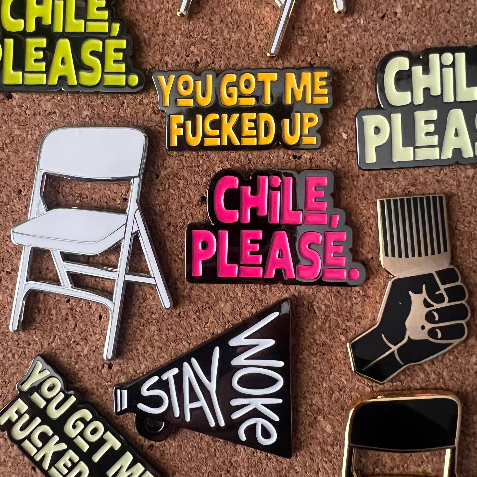 Collection of colorful pins with text and symbols on a brown background