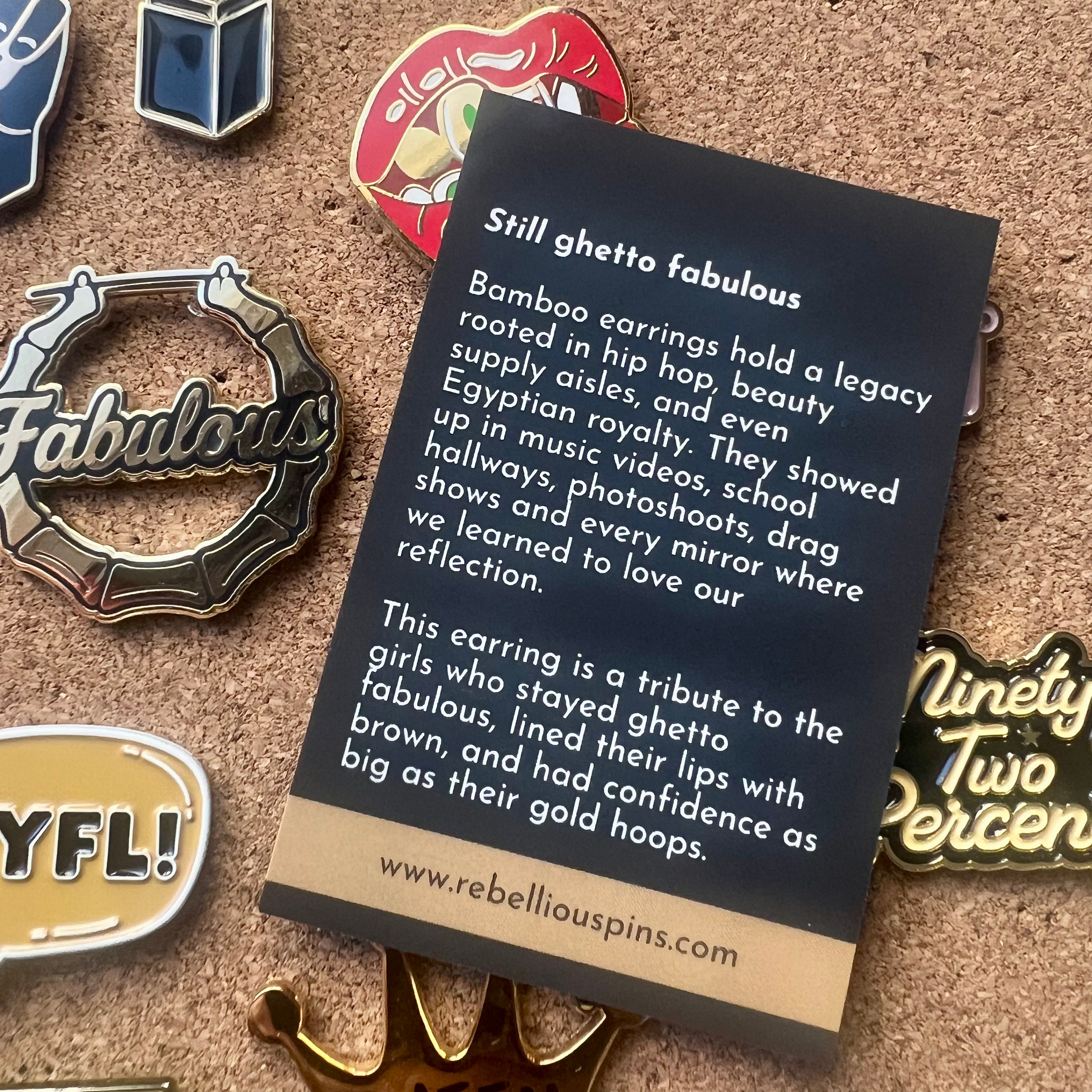 Card with text about bamboo earrings on a textured surface with pins displayed.