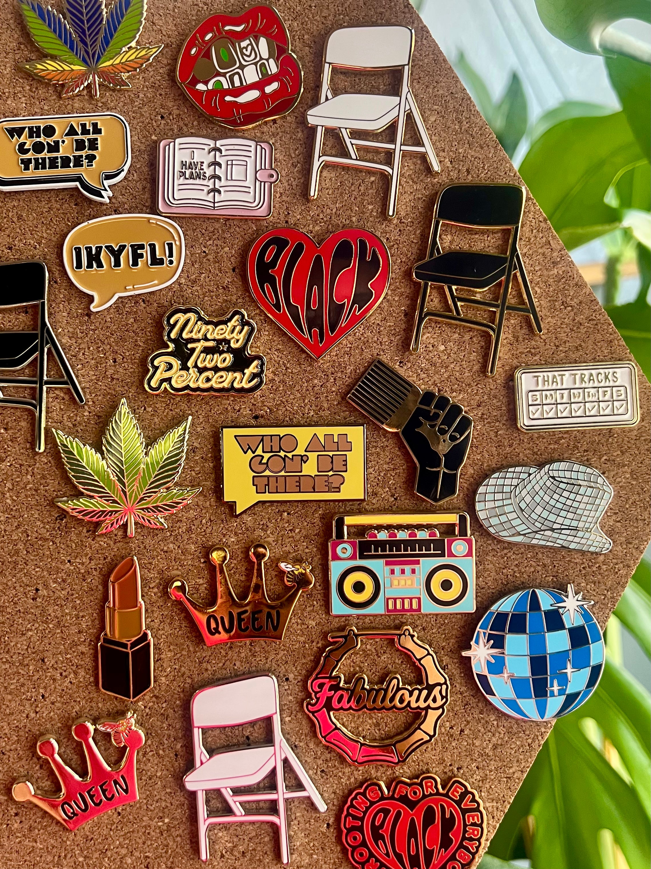 Collection of various pins on a cork board with a green leafy background