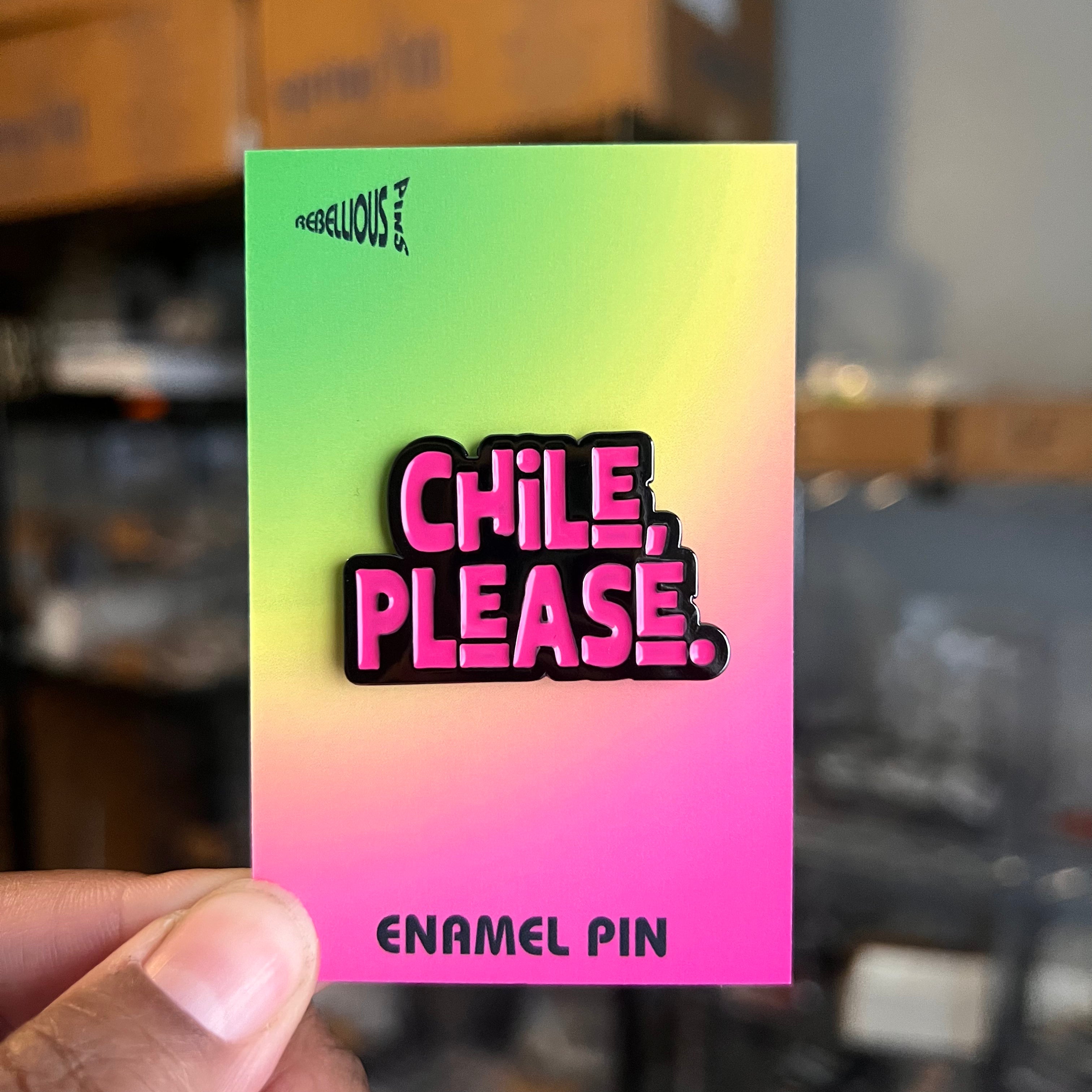 Enamel pin with 'Chile, Please' text on a gradient card held by a hand.