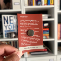 Card with text held in front of a bookshelf