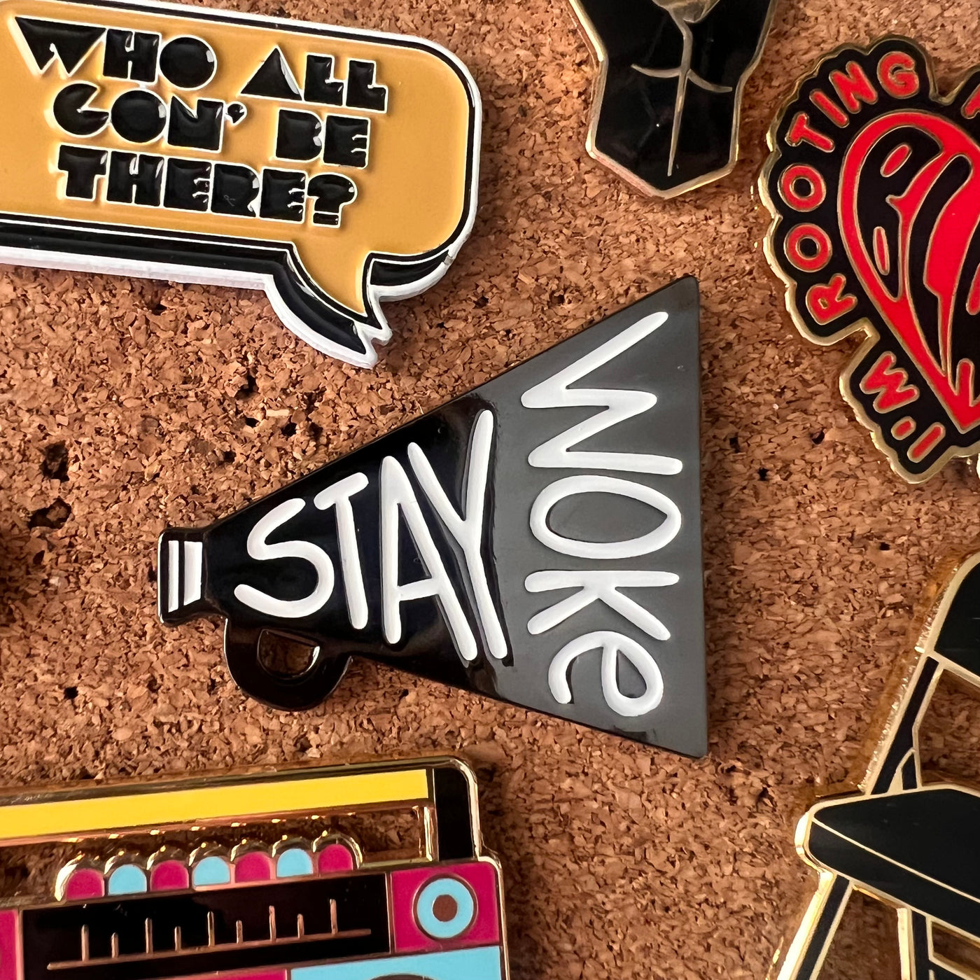 Collection of pins with various designs on a cork board background